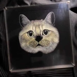 Final outline refinement on a handmade cat acrylic engraving, ensuring balance and visual consistency