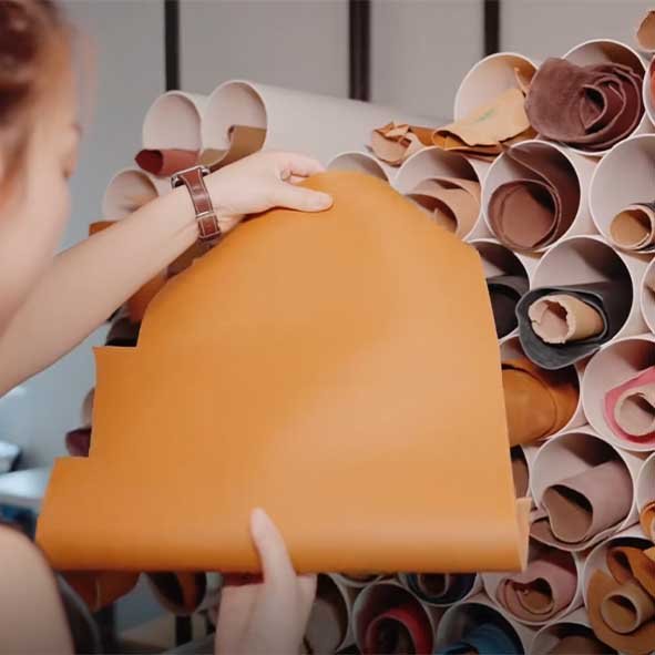 Artisan selecting premium leather sheets reserved for a custom pet memorial keepsake, ensuring material quality, craftsmanship, and personalized pet legacy creation