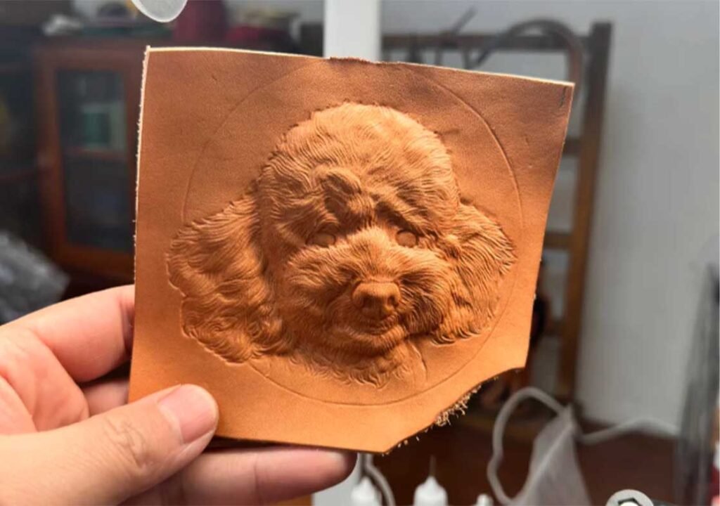 Hand-cut vegetable-tanned leather pet portrait carving process with realistic poodle detail.
