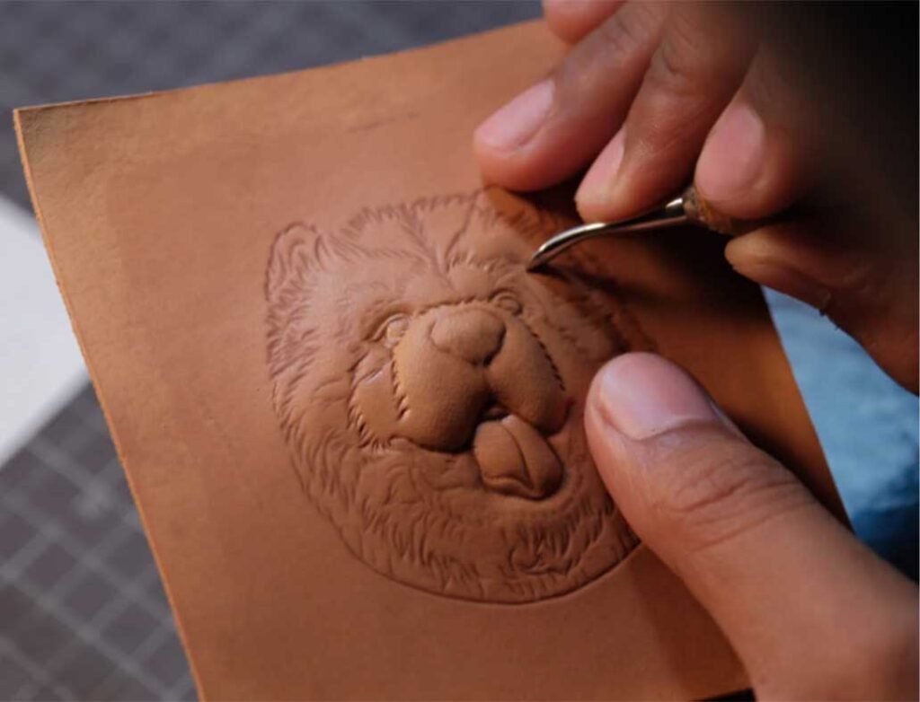 Artisan hand-carving a 3D dog portrait, demonstrating wet-forming and detailing on vegetable-tanned leather.