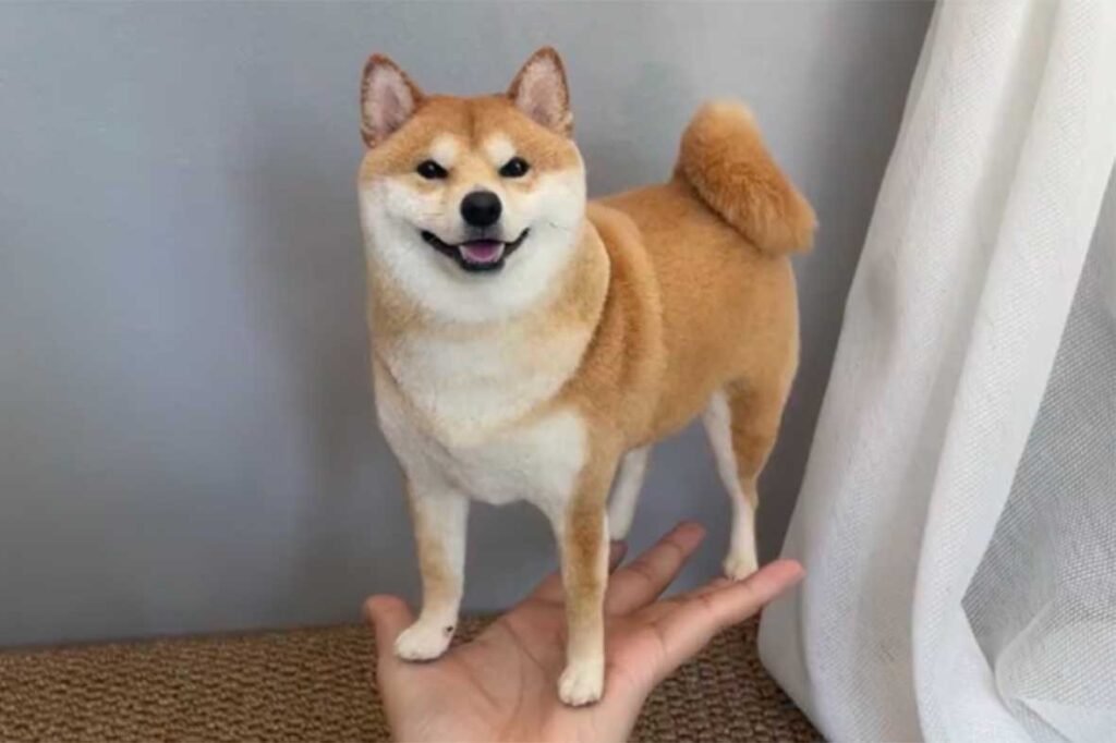 Realistic needle felted Shiba Inu dog sculpture standing on a human hand, showcasing bespoke handmade craftsmanship for pet lovers.