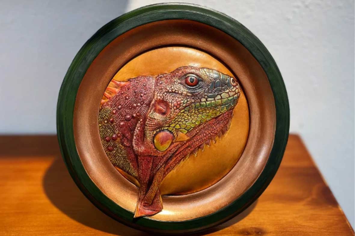 espoke leather art portrait of a Red Iguana in a circular wooden frame, showcasing 3D hand-carved textures and vibrant hand-painted details.