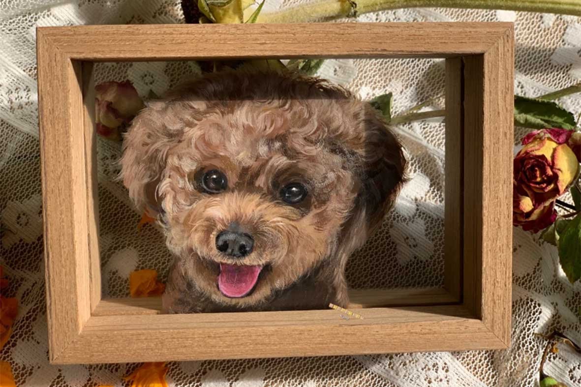 Custom pet portrait art in a wooden frame under warm accent lighting, demonstrating professional art lighting techniques for personalized decor.